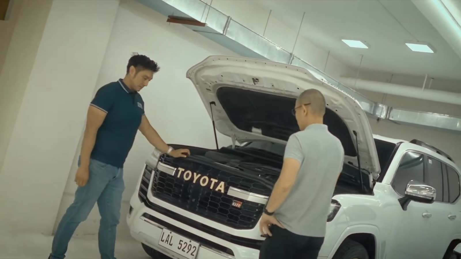 Two engineers checking a Toyota under the hood